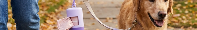 Luvairis Silicone Poop Bag Dispenser in use on a dog walk, bag partially dispensed
